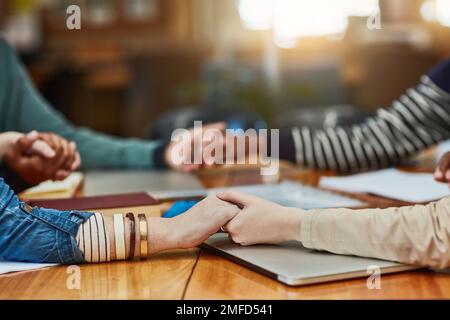 They rely on each others support and motivation. Closeup shot of an unidentifiable group of university students holding hands in prayer. Stock Photo