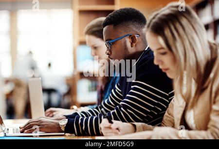 Everyone is hard at work for the test. a group of university students sitting in class at campus. Stock Photo