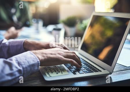 The perfect spot to spend the day working away. Closeup shot of an unrecognisable businessman working on a laptop at a cafe. Stock Photo