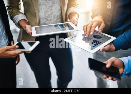 Ill share the information with you...unrecognizable businesspeople using their wireless devices in the office. Stock Photo