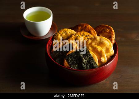 Sembei and green tea on the table. Sembei is a Japanese snack. Japanese image photo. Stock Photo