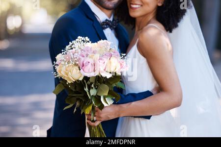 Flowers, wedding and marriage with a bride and groom posing outdoor for a photograph at their celebration event or ceremony. Rose bouquet, love and Stock Photo