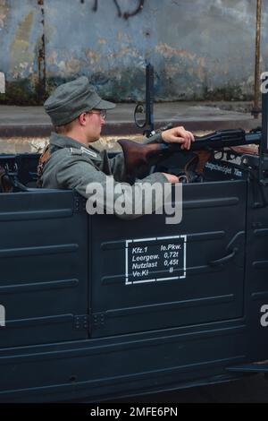 Hel, Poland - August 2022 Military troops marching during 3 May Polish Constitution Day ceremonial patriotic parade. Polish armed forces tanker military parade. Old guns and cars. Feast of Polish Armed Forces Day, American soldiers with US flag on parade Nato Vehicles Military Equipment  Stock Photo