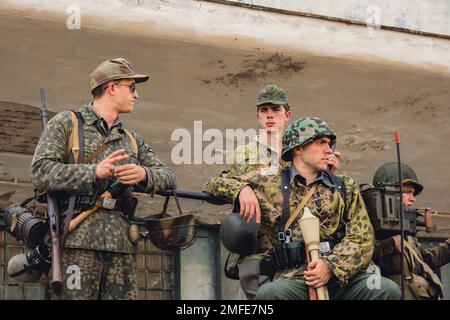 Hel, Poland - August 2022 Military troops marching during 3 May Polish Constitution Day ceremonial patriotic parade. Polish armed forces tanker military parade. Old guns and cars. Feast of Polish Armed Forces Day, American soldiers with US flag on parade Nato Vehicles Military Equipment  Stock Photo