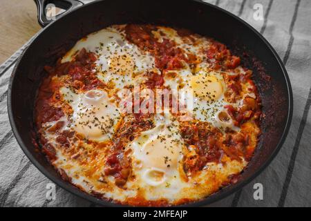 Home made Shakshuka, traditional North African and Middle Eastern dish on a pan, close up. Stock Photo