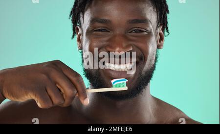 Black man, face and toothbrush, happy portrait with smile for teeth whitening and cleaning mouth isolated on studio background. Fresh breath, beauty Stock Photo
