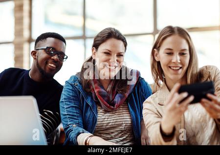 Lets get a photo in. a group of university students taking a selfie at campus. Stock Photo