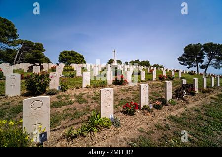 Graves, tombstones and red roses on the Agira Canadian War Cemetery, located on a hill near the town. Stock Photo