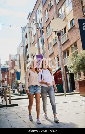 Taking in the sights. Low angle shot of two attractive young girlfriends exploring a foreign city. Stock Photo