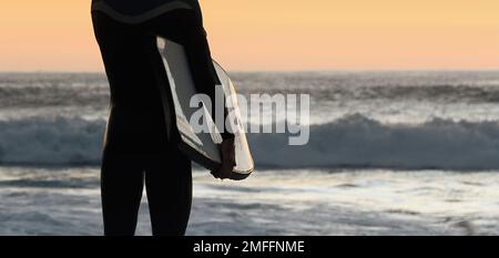 Silhouette of young male surfer on the beach at sunset Stock Photo - Alamy