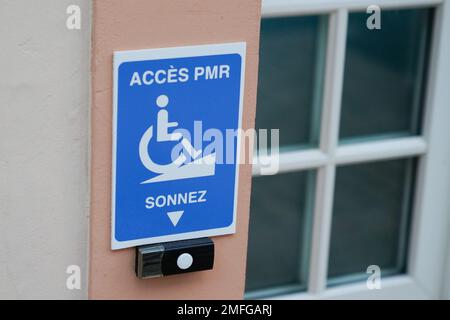 disabled accessible arrow entry sign post with wheelchair handicap logo pmr means  people someone with reduced mobility on wall entrance store access Stock Photo