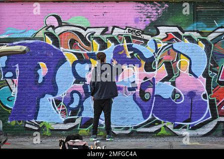 The Netherlands, Amsterdam: street artists at work, realizing colorful murals on the walls of the Straat Museum (graffiti and street art museum) in ND Stock Photo