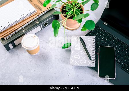 Top view of computer desk with keyboard, smartphone, stationery and coffee cup Stock Photo