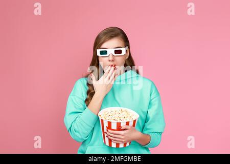 woman in sweatshirt holding bucket of popcorn Stock Photo