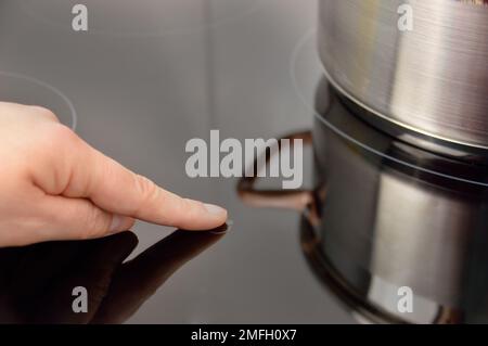 Woman select function on Induction stove Stock Photo - Alamy