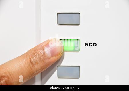 finger activating the eco button in concept of clean energy and save Stock Photo