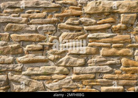 Old stone wall of a building. Stone wall as background or rustic pattern for wallpaper. Stock Photo