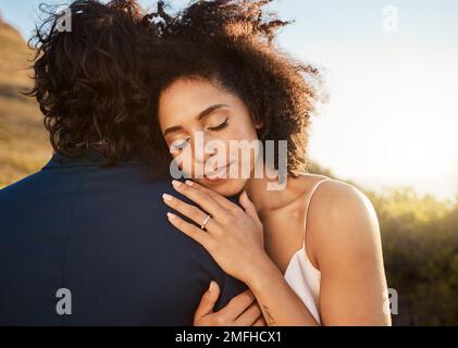 Wedding, bride and groom hug at sunset with embrace together for care, love and support in married life. Marriage, black woman and man at romantic Stock Photo