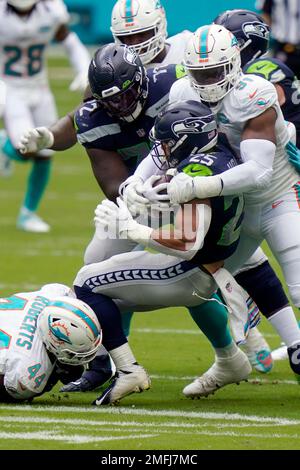 Miami Dolphins defensive tackle Josiah Bronson (95) reacts after taking  down Jacksonville Jaguars running back Travis Etienne Jr. (1) during the  first quarter of an NLF preseason football gam Saturday, Aug. 26