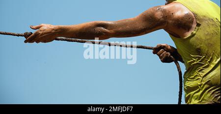 Mud race runners,defeating obstacles by using ropes,tug of war Stock ...
