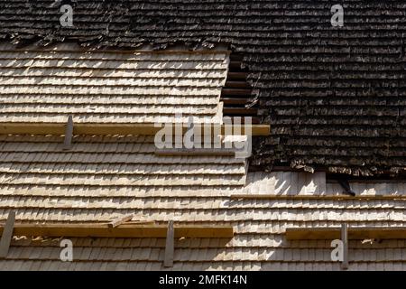 Roof construction site. Removal of old roof, replacement with new shingles, equipment and repair. Roofs are a very important part of all housing proje Stock Photo