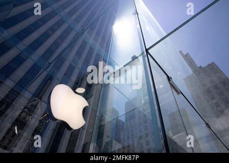 FILE - In this June 16, 2020, file photo, the sun is reflected on Apple's Fifth Avenue store in New York. Apple will cut its app store fee in half from 30% to 15% for most developers beginning Jan. 1, the biggest change in its commission rate since the app store began in 2008. The fee reduction will apply to developers who made up to $1 million from the app store in 2020, which is the “vast majority” of developers in the store, Apple said. (AP Photo/Mark Lennihan, File)