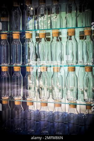 A decorative wall with rows of identical glass bottles Stock Photo