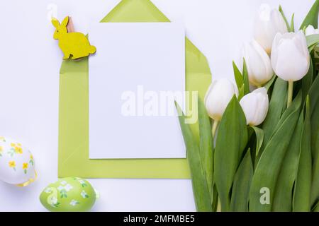 Template for Easter greeting card. Blank card with an envelope and bouquet of white tulips Stock Photo
