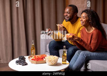 Side view of black spouses watching movie or TV show Stock Photo