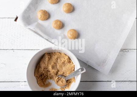 Fresh dough for making gingerbread cookies on white background in a bowl with baking sheet Stock Photo