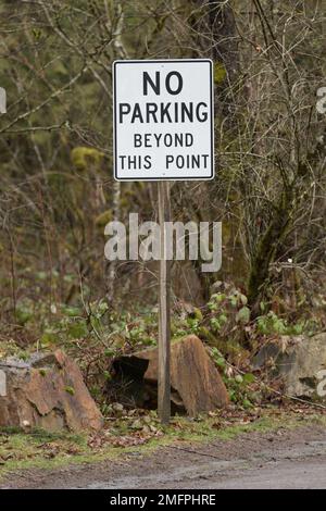 Signpost in rural setting with text in black on white stating no parking beyond this point Stock Photo