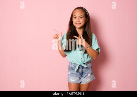 Portrait of adorable kind sweet little girl impressed face expression promote offer isolated on pink color background Stock Photo