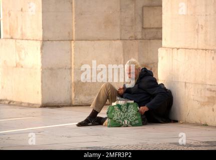 Man with long beard begs for money in the streets of Lisbon Stock Photo