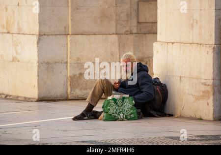 Man with long beard begs for money in the streets of Lisbon Stock Photo