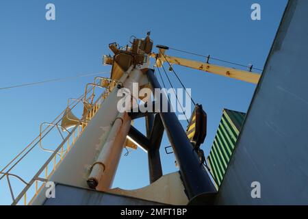 View on forward vessel cream colour mast with ladder and ship's foghorn in low angle. Stock Photo