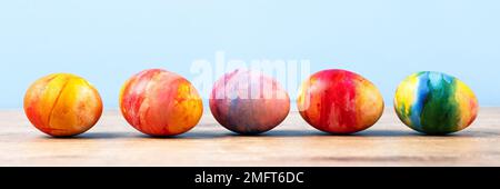 Colorful Easter eggs on a wooden background with a place for text. Happy Easter concept. Banner Stock Photo