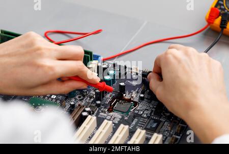 high angle female technician repairing computer motherboard. High resolution photo Stock Photo