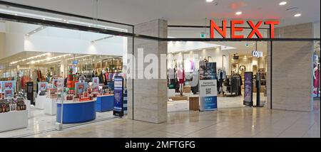Next plc retail business clothing fashions store sign and open plan entrance from a Thurrock Essex Lakeside shopping centre indoor mall England UK Stock Photo