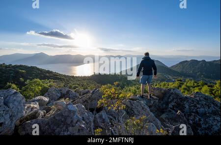 Hiker looking over volcanic peninsula Methana, view over sea and ...