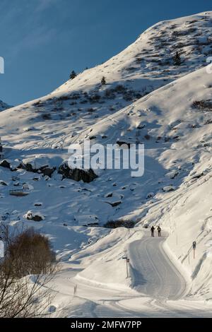Two people in the distance walking along a trail in les menuires Stock Photo