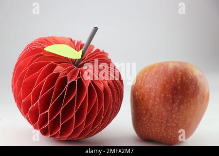 Special apple made using paper as a craft with real apple kept next to it Stock Photo