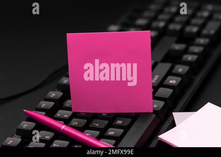 Sticker lying on black keyboard. Important message written over paper. Stock Photo
