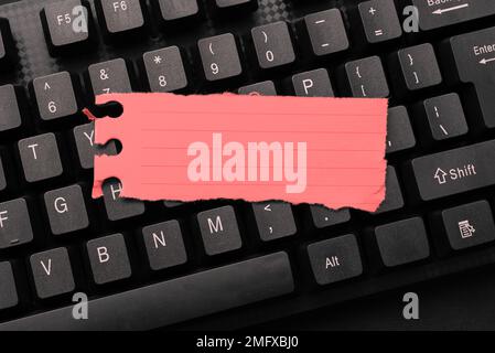 Colored sticker lying on keyboard. Important message written over paper. Stock Photo