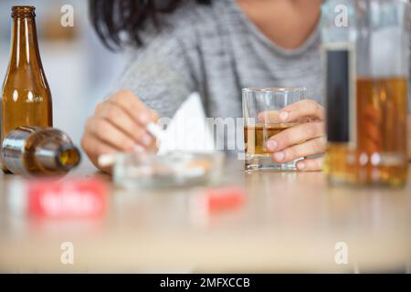 woman hands holding a cigarette and drinking alcohol Stock Photo