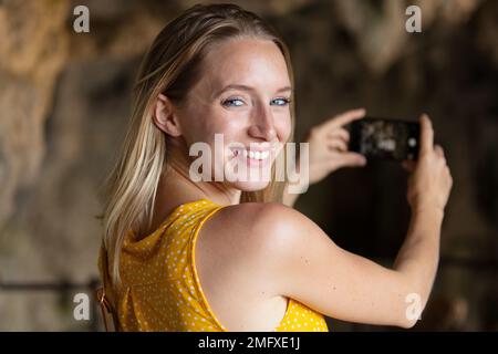 female woman taking a selfie in a cave Stock Photo