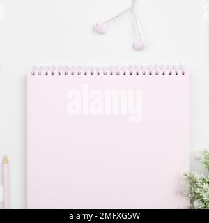 Pot with Plant and Coffee Cup Standing on White Desk. Important infrormation written on paper. Different Office Supplies, Pencils, Pens, Marckers Stock Photo