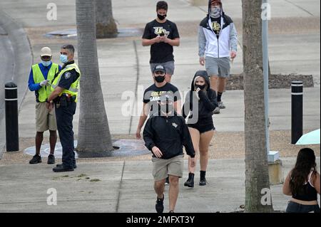 Fans wear masks while walking in the gift shop before a baseball game  between the Los Angeles Angels and the Houston Astros Monday, April 5,  2021, in Anaheim, Calif. (AP Photo/Marcio Jose