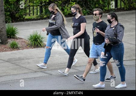 Fans wear masks while walking in the gift shop before a baseball