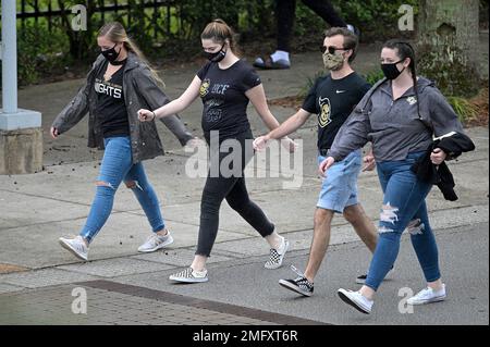 Fans wear masks while walking in the gift shop before a baseball game  between the Los Angeles Angels and the Houston Astros Monday, April 5,  2021, in Anaheim, Calif. (AP Photo/Marcio Jose