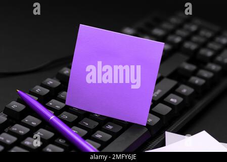 Colored sticker lying on keyboard. Important message written over paper. Stock Photo